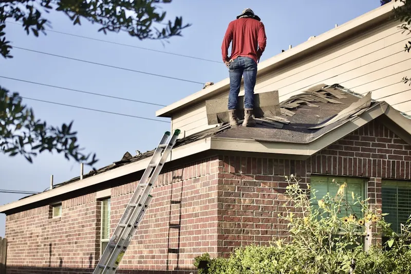 Professional roofer working on a residential roof in Corbin Heights Housing